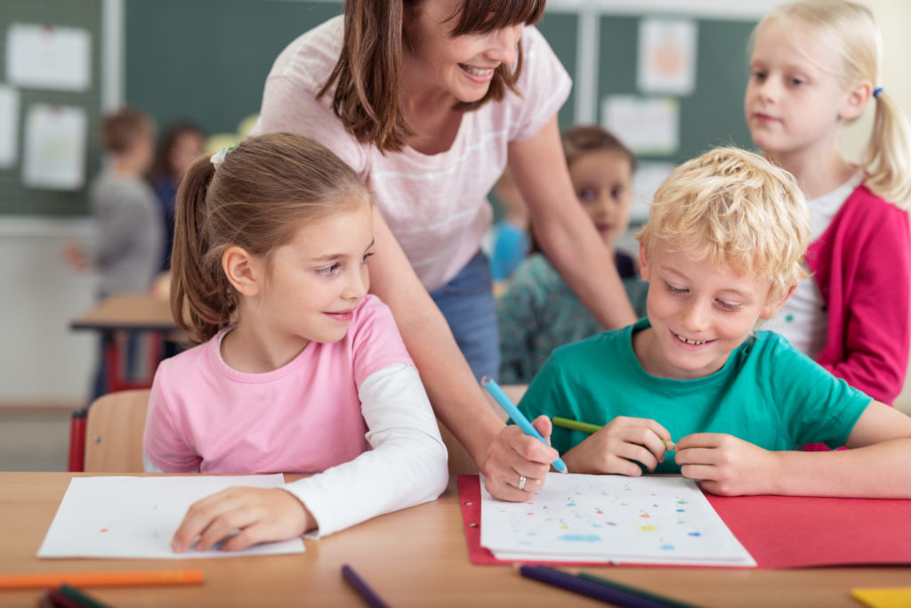 lehrerin mit einer gruppe kinder in der klasse