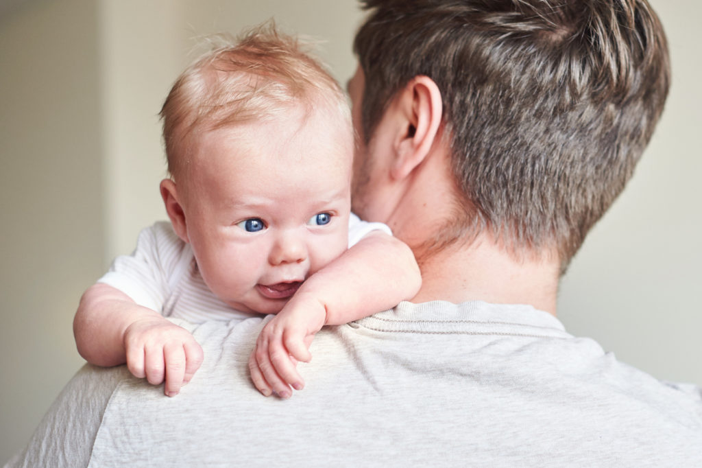 Happy father holding newborn baby in his arms.