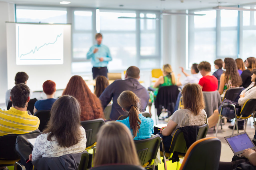 Speaker at business workshop and presentation. Audience at the conference room.