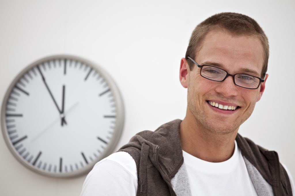 lächelnder Mann und eine Uhr