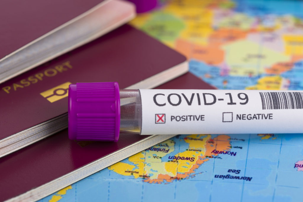 Coronavirus and travel concept. Epidemic in Wuhan, China. World map showing countries with COVID-19 cases. Blood sample in a tube, world map, passport and mask. Travel restrictions and quarantine