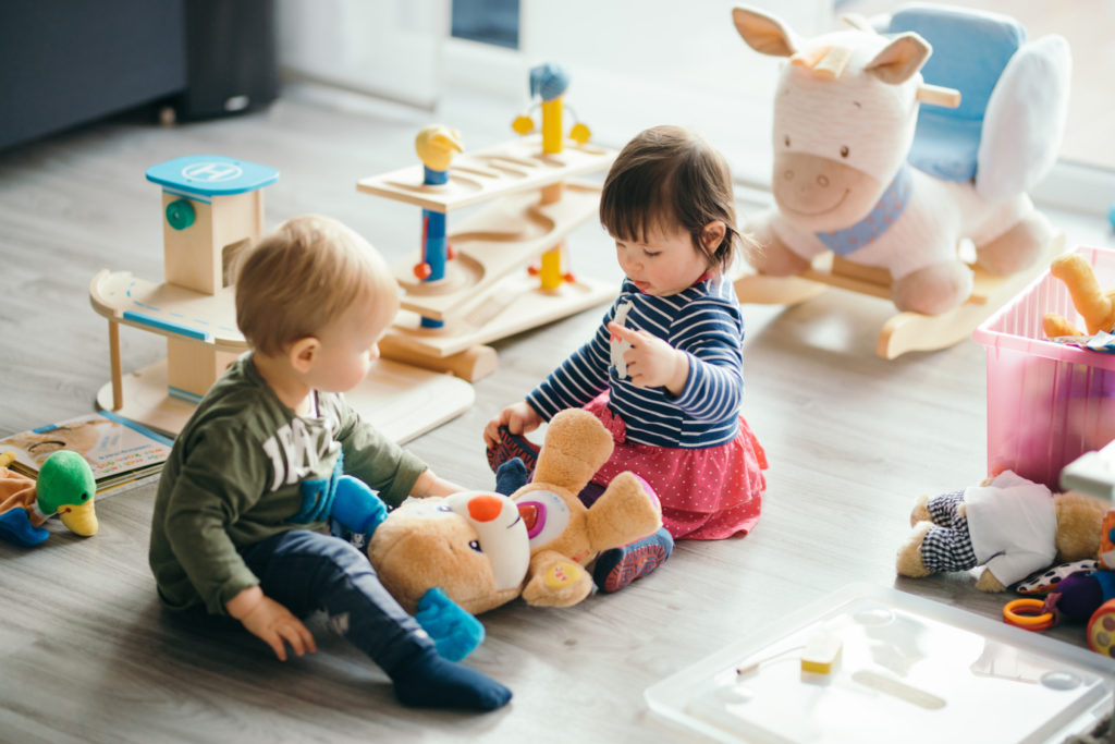 cute little girl and boy playing with toys by the home