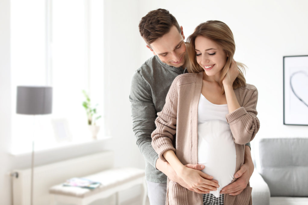 Young pregnant woman with her husband at home