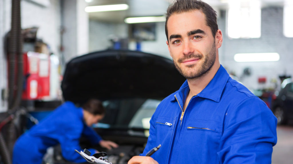 View of a Young attractive mechanic working at the garage