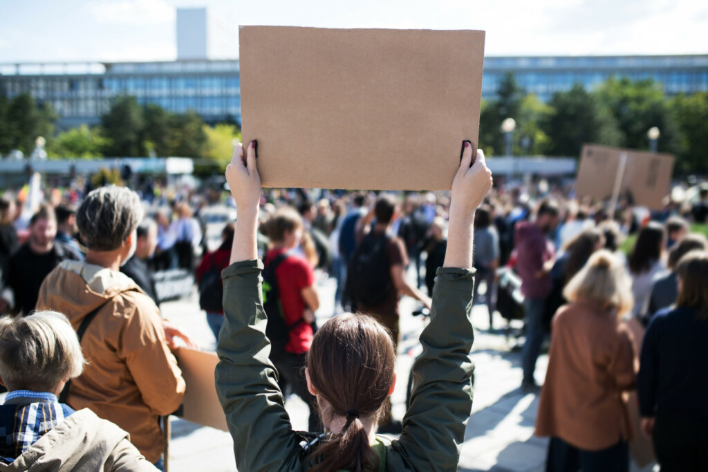 A rear view of people with placards and posters on global strike for climate change. Copy space.