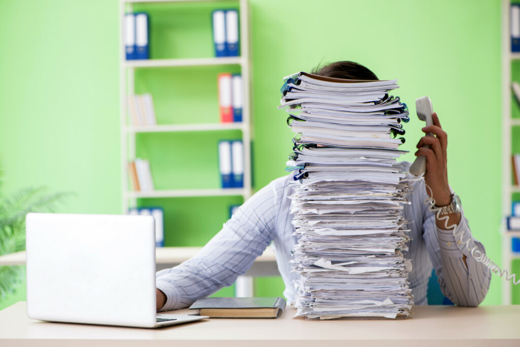 Businessman having problems with paperwork and workload