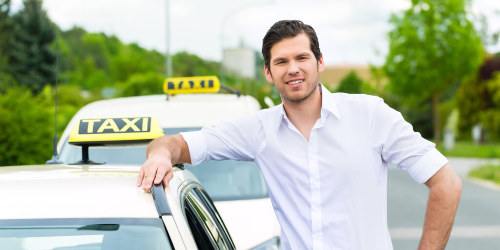 Experienced taxi driver in front of his taxi, waiting for a passenger