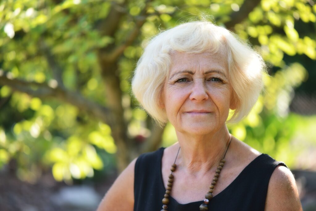 Mature, blonde woman in garden,