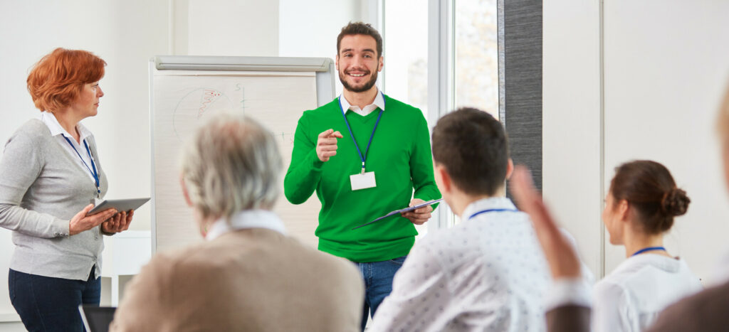Business Team im Consulting Seminar diskutiert mit dem Berater oder Dozenten