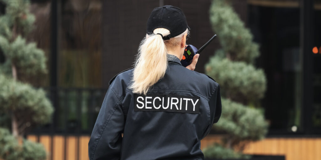 Female security guard outdoors, back view